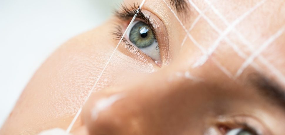 Woman during professional eyebrow mapping procedure